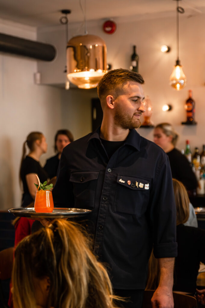 Teenindaja viib kandikuga kohtunikele erimenüü kokteili Tartu Cocktail Week, pildistas Tartu fotograaf Mailis Vahenurm